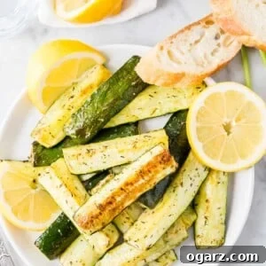 Roasted Zucchini on a white plate garnished with lemon slices