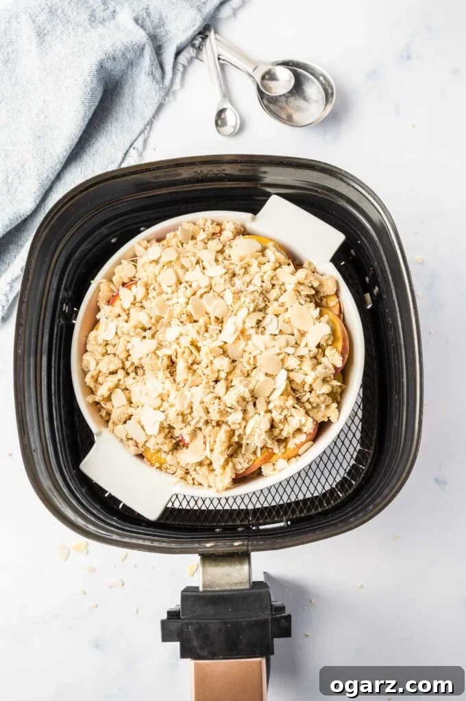 Golden Air Fryer Peach Delight 5 An assembled peach crisp in a baking pan, ready to go into an air fryer basket