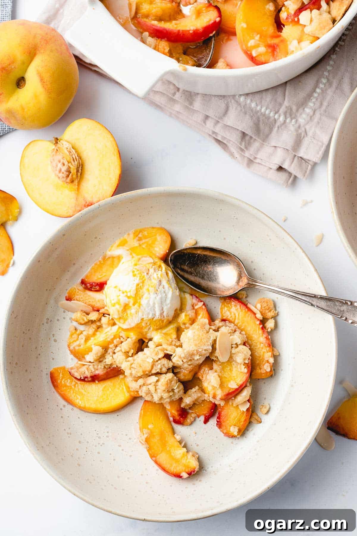 Golden Air Fryer Peach Delight 8 Top down shot of a plate with peach crisp, streusel topping, and a scoop of vanilla ice cream