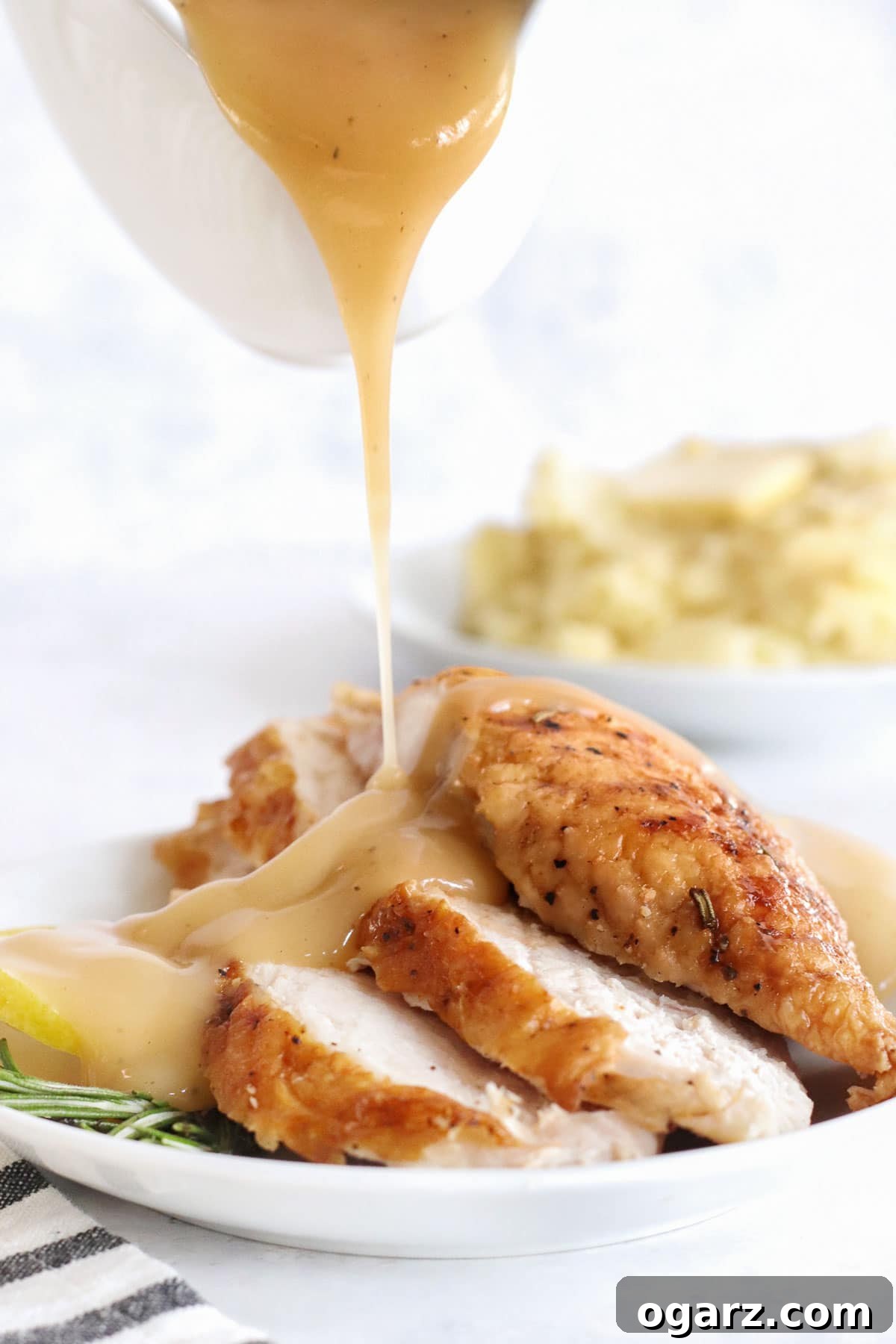 Crispy Air Fryer Turkey Breast 7 Rich gravy being generously poured onto slices of turkey breast arranged on a plate