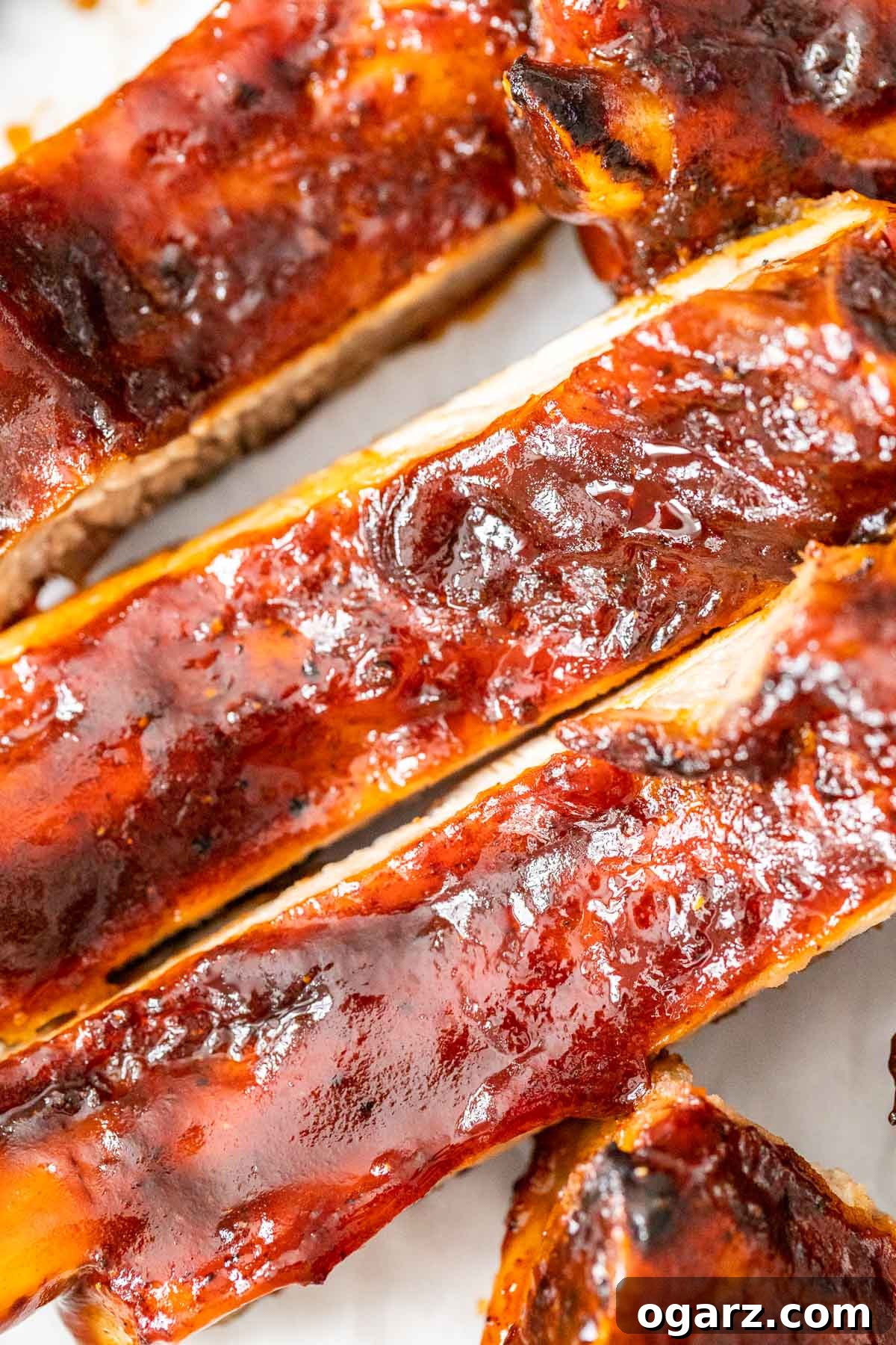 Perfect Air Fryer Ribs 6 A close up of BBQ ribs on white parchment paper.