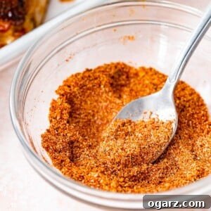 Ultimate Barbecue Blend 7 A glass bowl filled with BBQ seasoning and a spoon in it.