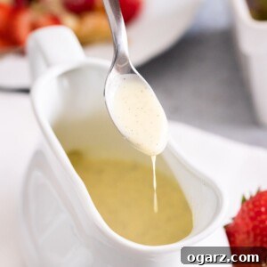Vanilla sauce gracefully dripping from a spoon into a bowl, highlighting its perfect, pourable consistency.