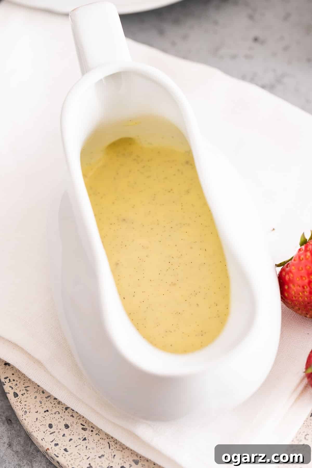 Silken Vanilla Crème 5 A pristine white sauce boat brimming with golden vanilla custard sauce, ready to be poured over a delectable dessert.