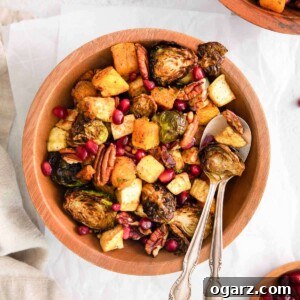 Roasted vegetables in a wooden bowl with a serving spoon.
