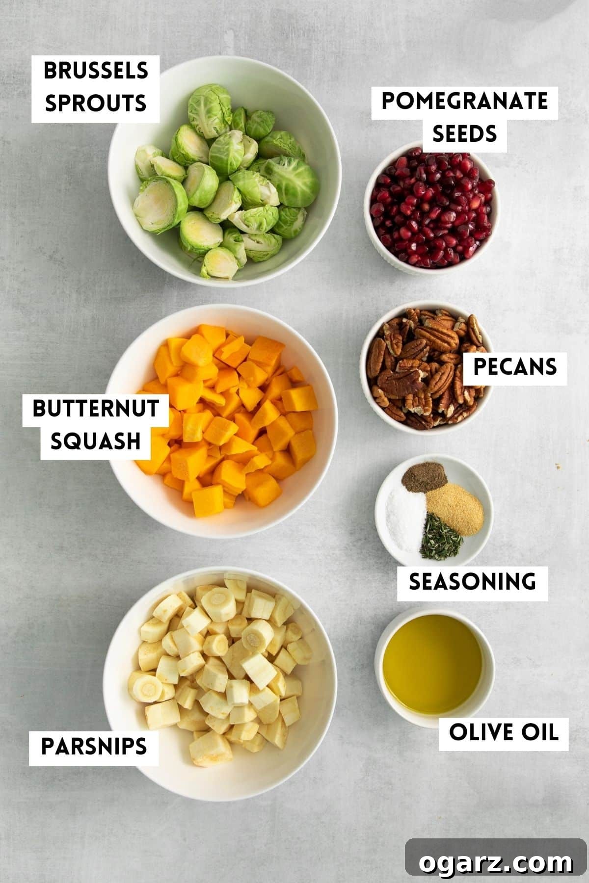 Golden Crispy Air Fryer Vegetables 3 A flat lay photograph showcasing the fresh ingredients laid out on a cutting board, ready for making roasted vegetables in the Air Fryer. Includes butternut squash, Brussels sprouts, parsnips, rosemary, garlic powder, olive oil, pecans, and pomegranate.