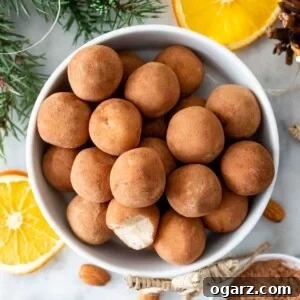 Marzipan Potato Treats 7 Marzipankartoffeln in a white bowl, next to it are orange slices and almonds.