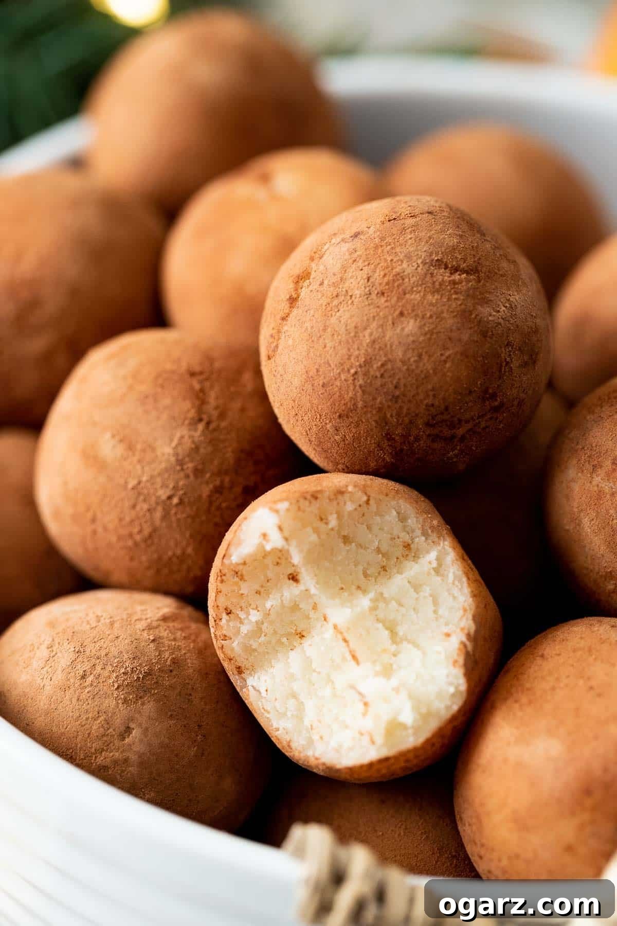 Marzipan Potato Treats 6 German marzipan potatoes in a white bowl, one ball has a bite taken out of it, showing its soft texture.