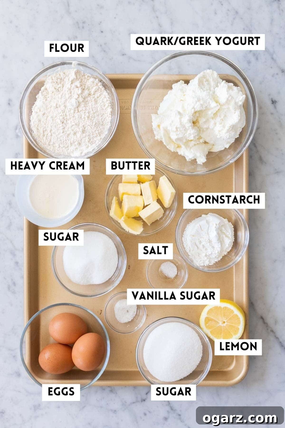 Käsekuchen: The German Cheesecake 3 A collection of ingredients artfully arranged on a kitchen surface, showcasing everything needed for baking an authentic German Cheesecake.