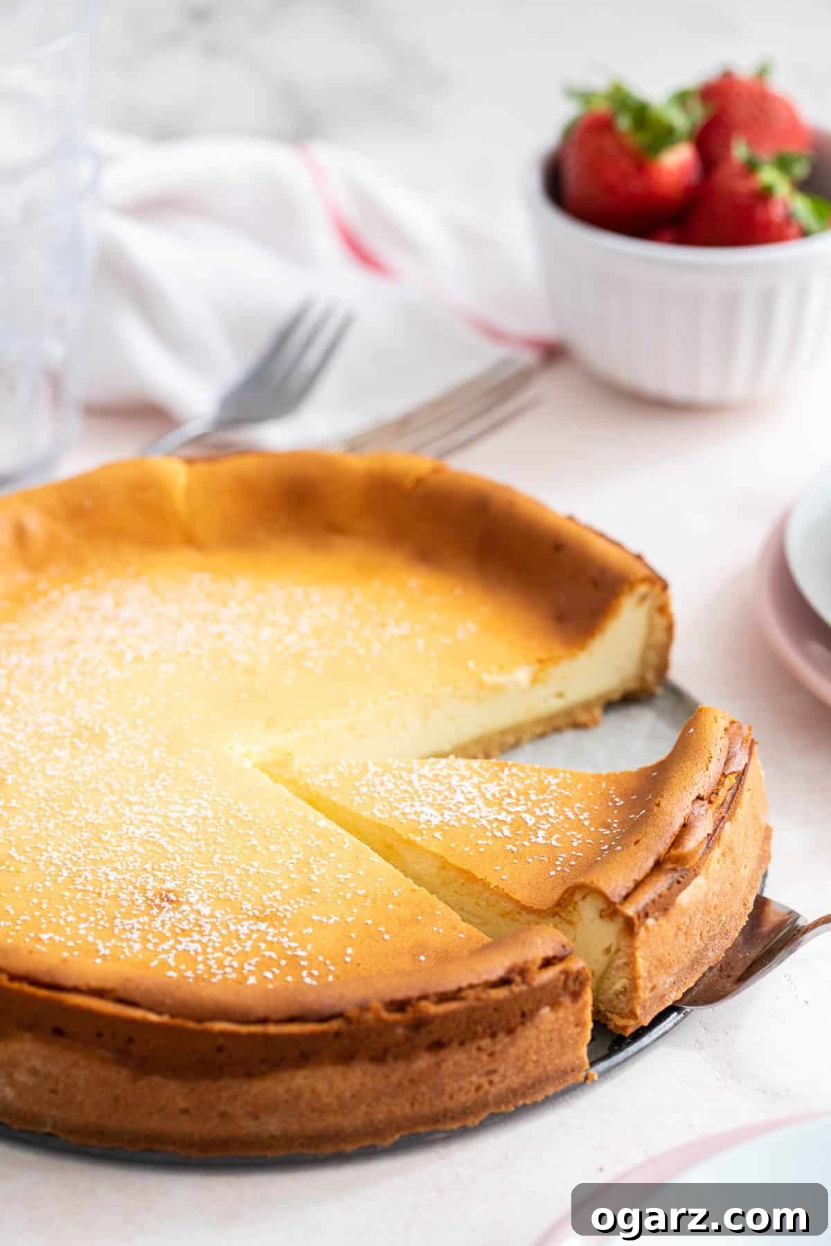 Käsekuchen: The German Cheesecake 7 A magnificent whole German cheesecake presented on a decorative cake stand, ready to be sliced and served, showcasing its golden crust and creamy interior.