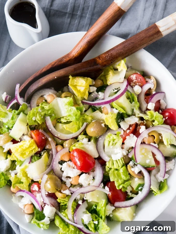 Refreshing Balsamic Chickpea Feta Greek Salad 4 A close-up shot of the fresh ingredients for Balsamic Chickpea Feta Greek Salad including perfectly crumbled feta cheese, thoroughly rinsed chickpeas, bright red grape tomatoes, and briny green olives, ready for mixing.