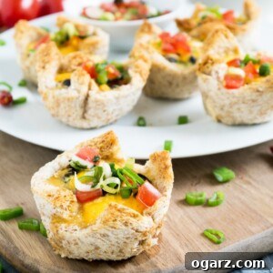 A white plate with cheesy Mexican toast cups garnished with chives on a wooden cutting board. There's a single toast cup in front.