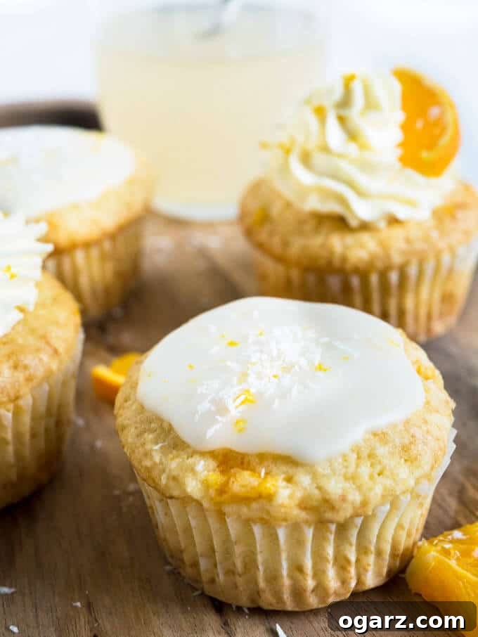 Nostalgic Orange Cream Cupcakes 3 Close-up of fluffy Coconut Orange Creamsicle Cupcakes, showcasing their vibrant color and delicate texture.