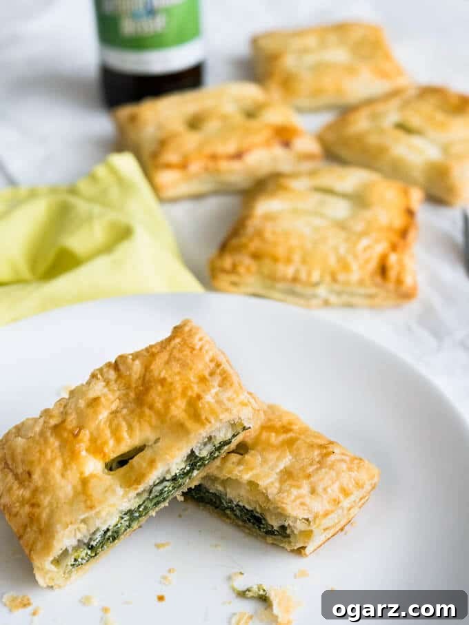 Spinach Ricotta Puff Pastry Pockets 5 Several Spinach & Ricotta Puff Pastry Parcels neatly arranged on a tray, showcasing their perfect shape and golden hue.