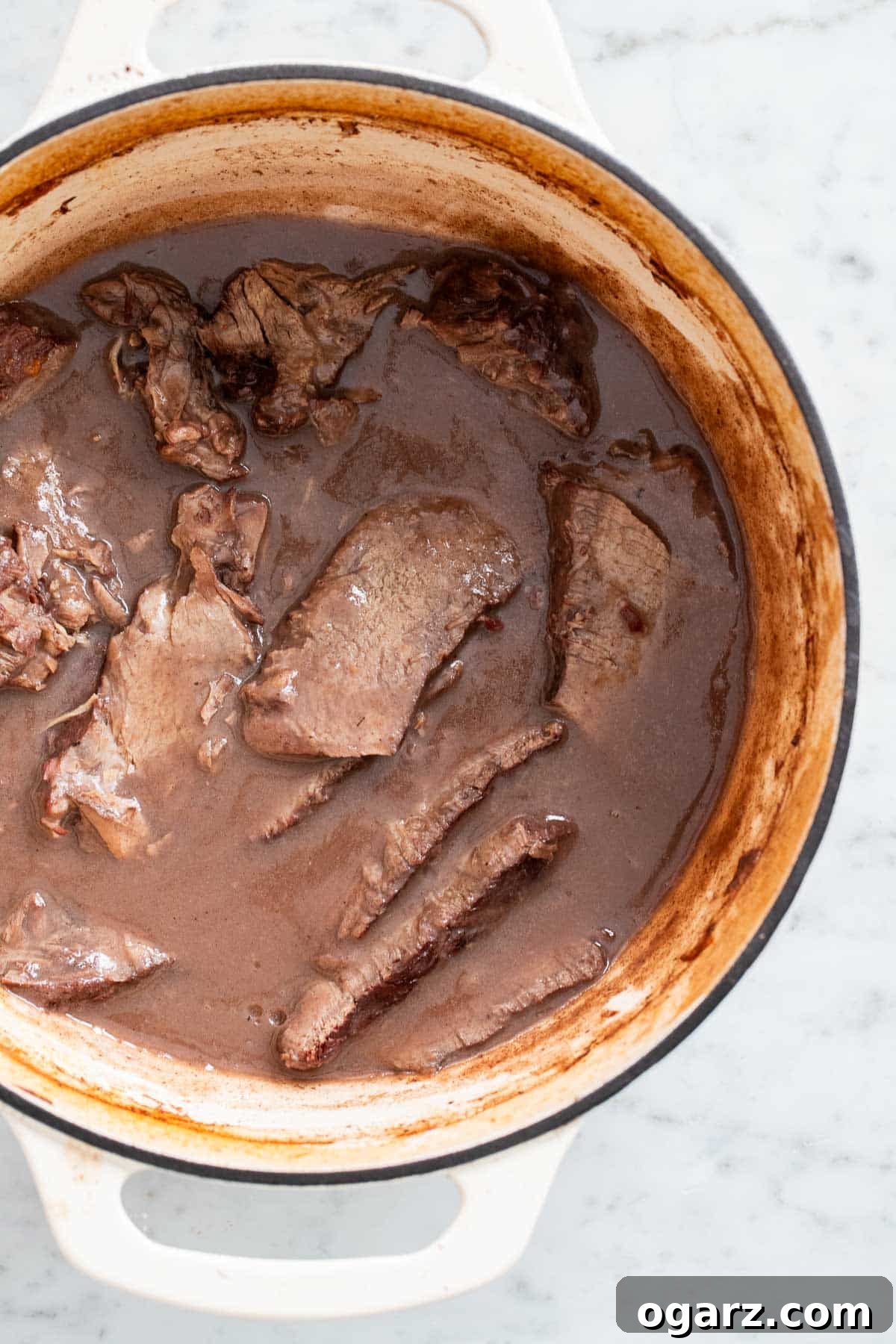 Tangy German Pot Roast 12 Sliced roast and gravy in a Dutch oven.