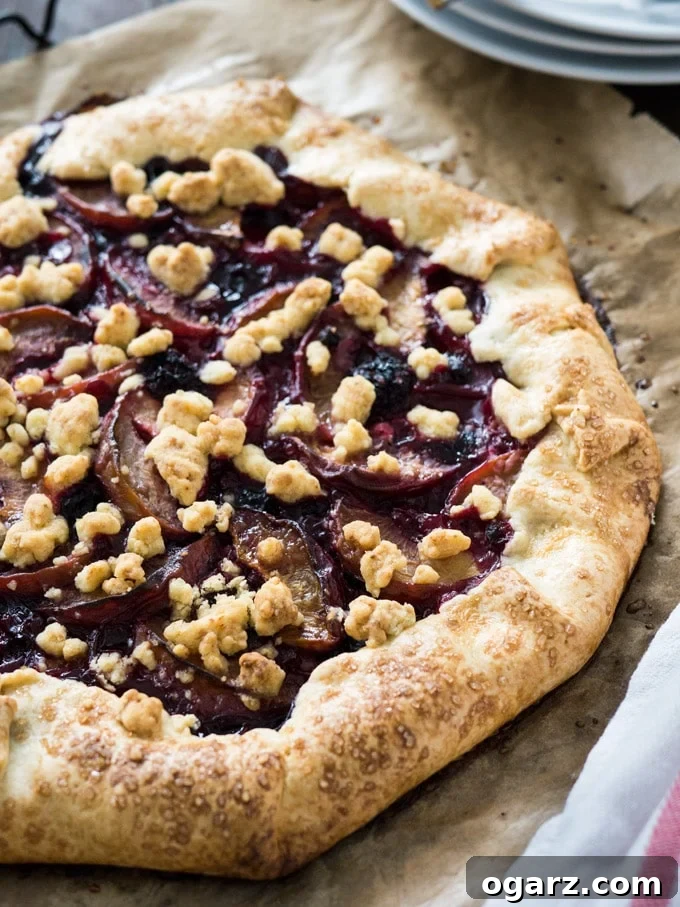 Close-up of a rustic Peach and Berry Crostata with streusel topping, showcasing the vibrant fruit peeking from under the golden crust, ready to be sliced.