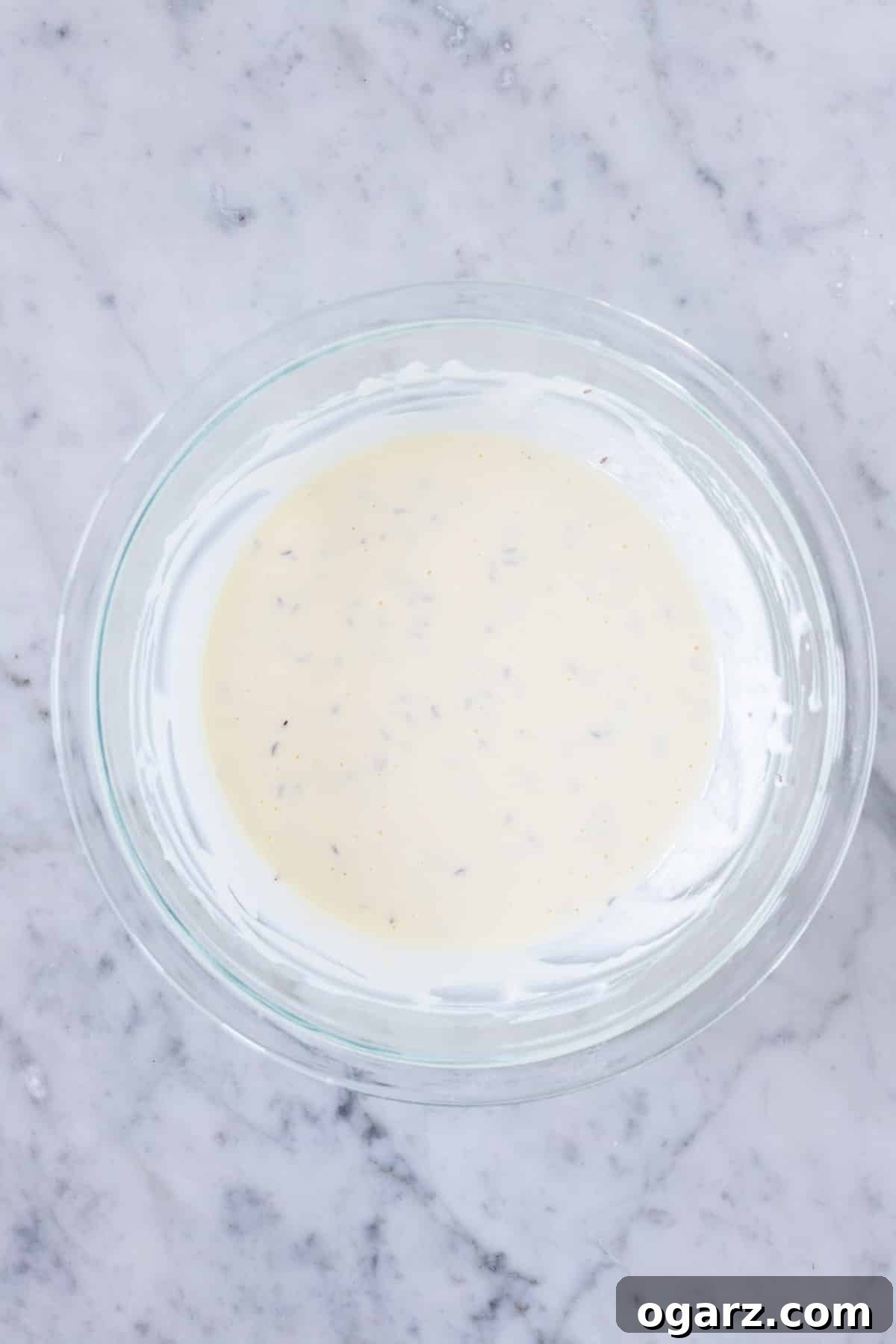 Custard mixture with onions and eggs in a bowl, ready for the pie.