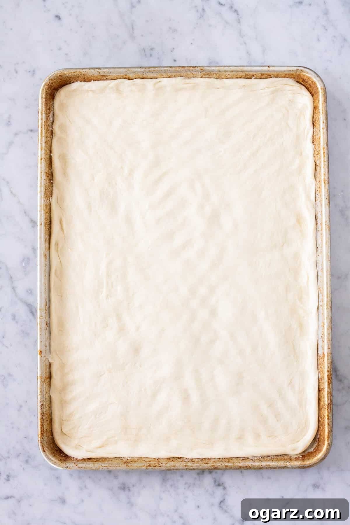 Dough rolled out on a baking sheet, ready for the filling.