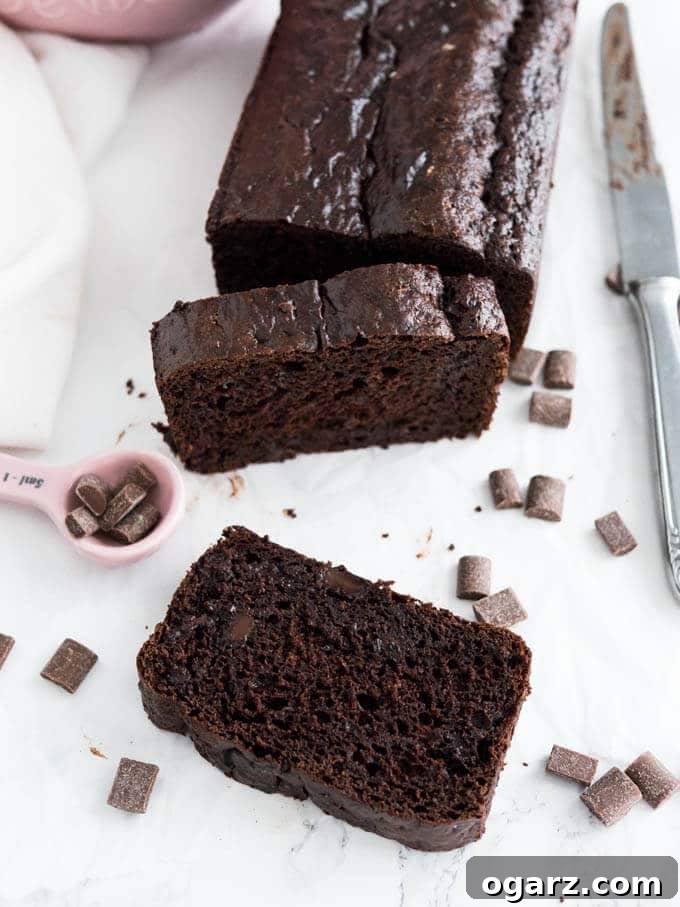 Three slices of decadent Double Chocolate Chip Bread on a white plate, ready to be enjoyed. A perfect snack or breakfast item.