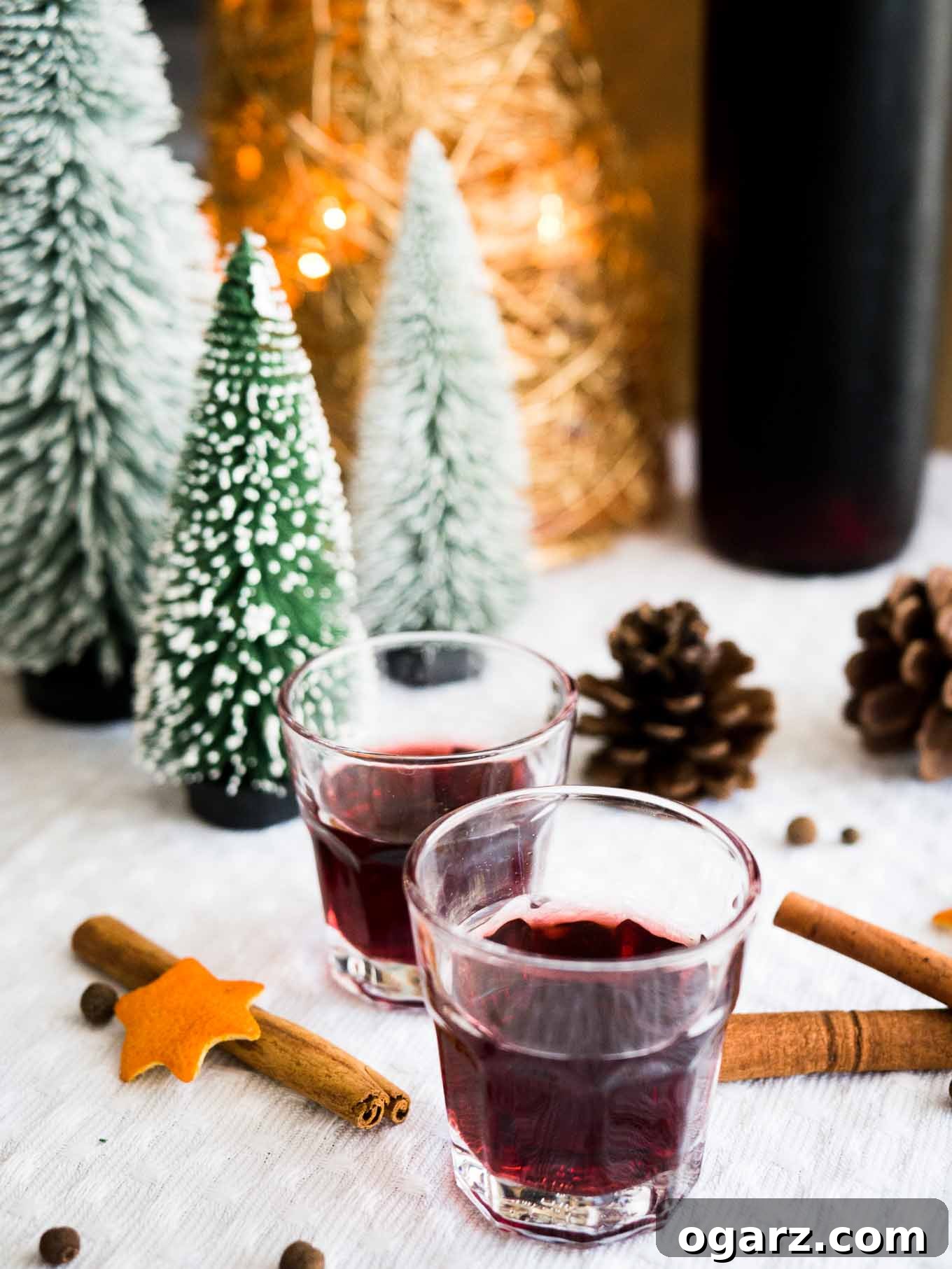 Close-up of mulled wine liqueur being strained into a glass bottle, showing the rich color and aromatic spices.