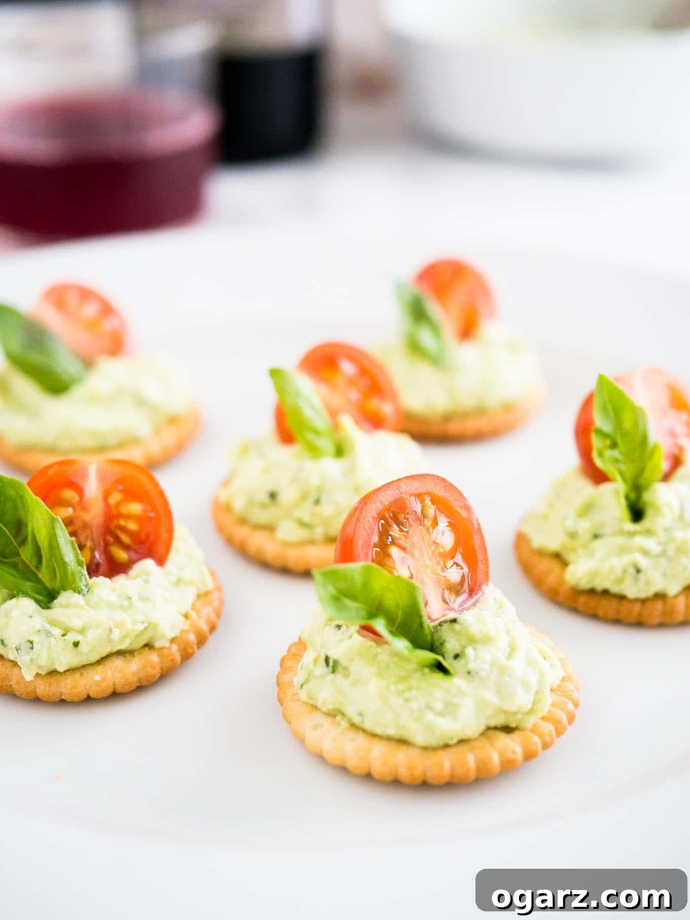 Mediterranean Tomato Feta Poppers 4 Feta Tomato Bites arranged on a platter with fresh basil, ready to be enjoyed.