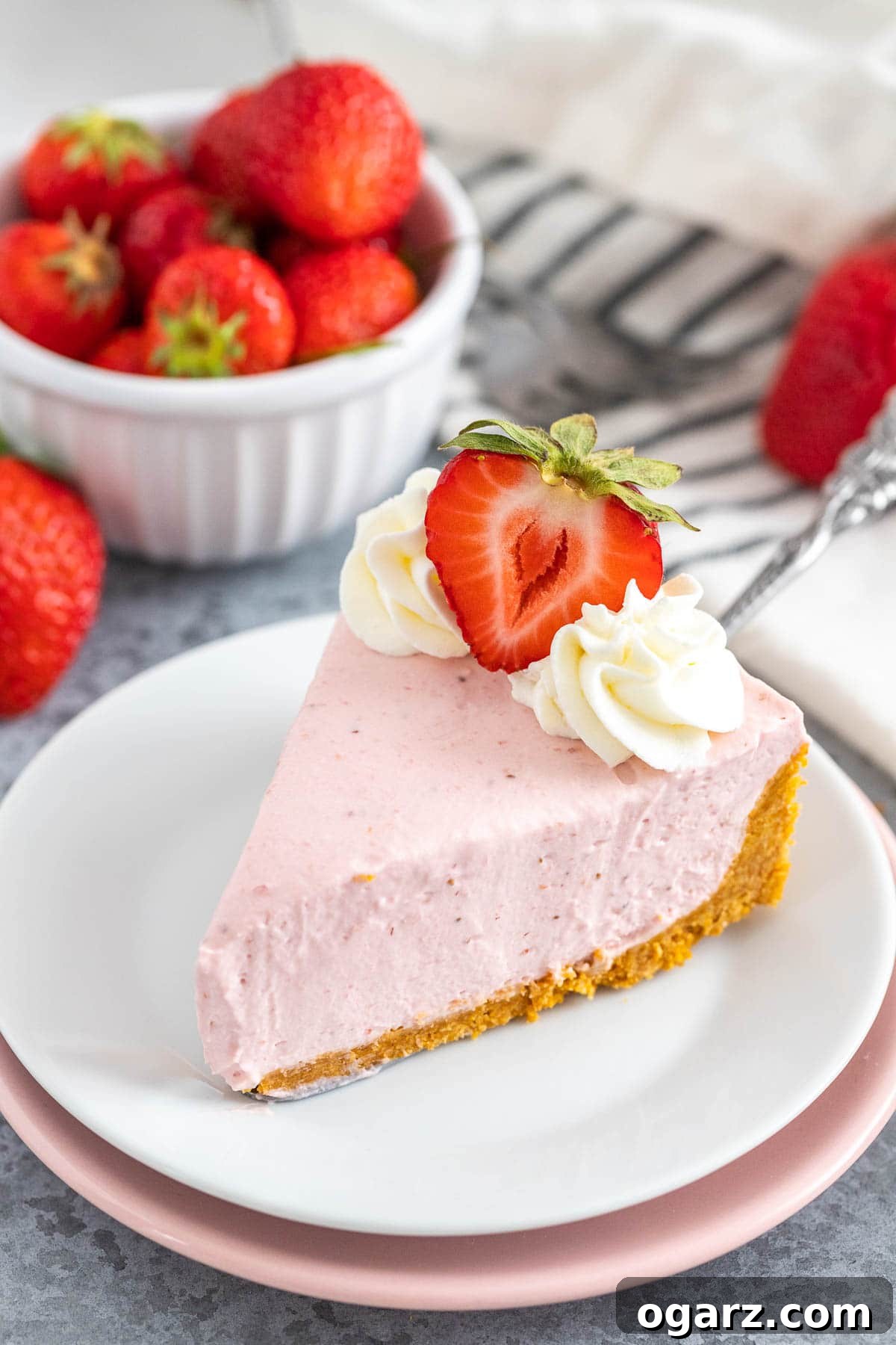 Effortless Strawberry Cheesecake Bliss 2 A vibrant slice of No-Bake Strawberry Cheesecake on a white plate, garnished with fresh berries.
