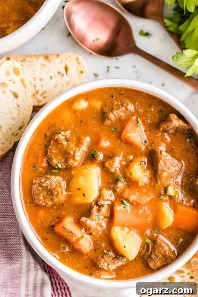 Effortless Instant Pot Beef Stew 2 A bowl of beef stew with a spoon and bread next to it