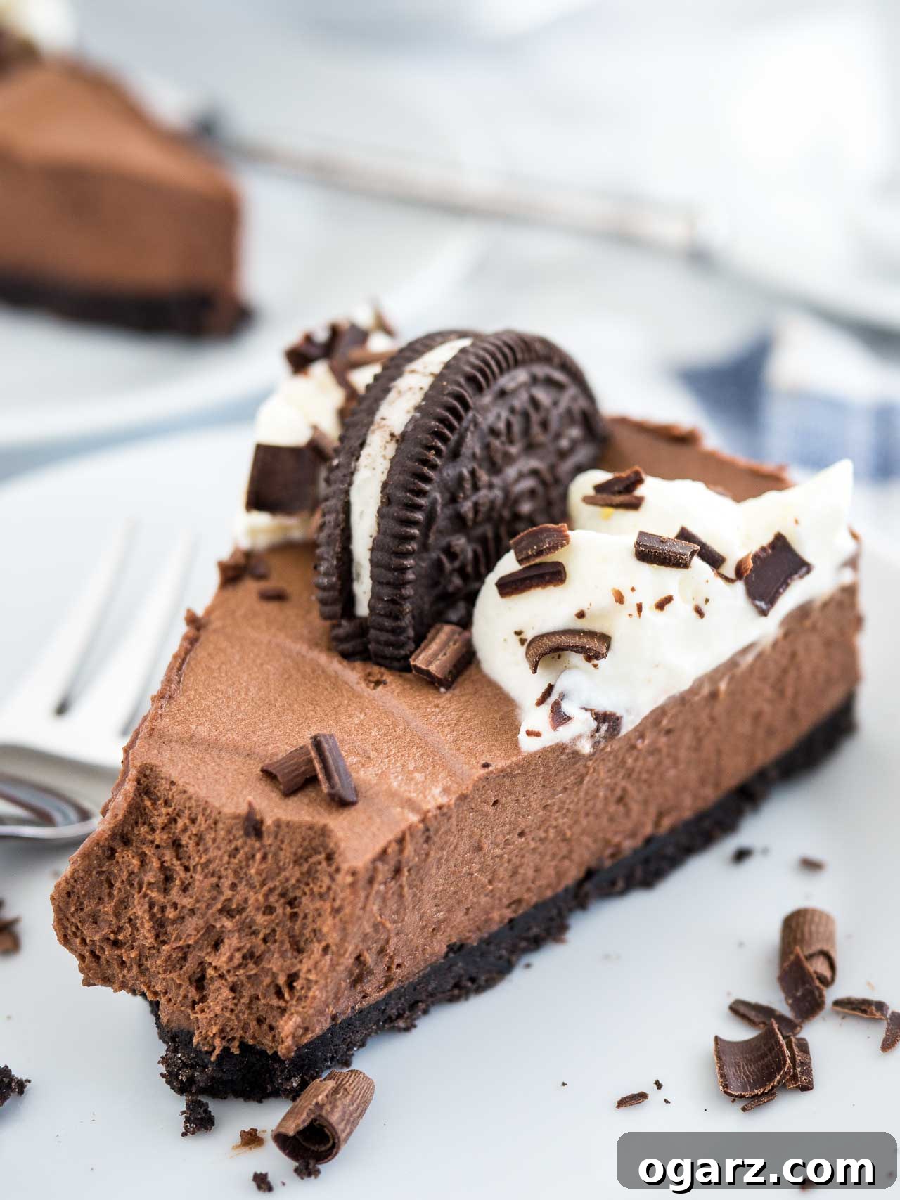 Decadent Chocolate Mousse Dream 3 A slice of chocolate mousse cake on a marble surface with a fork next to it.