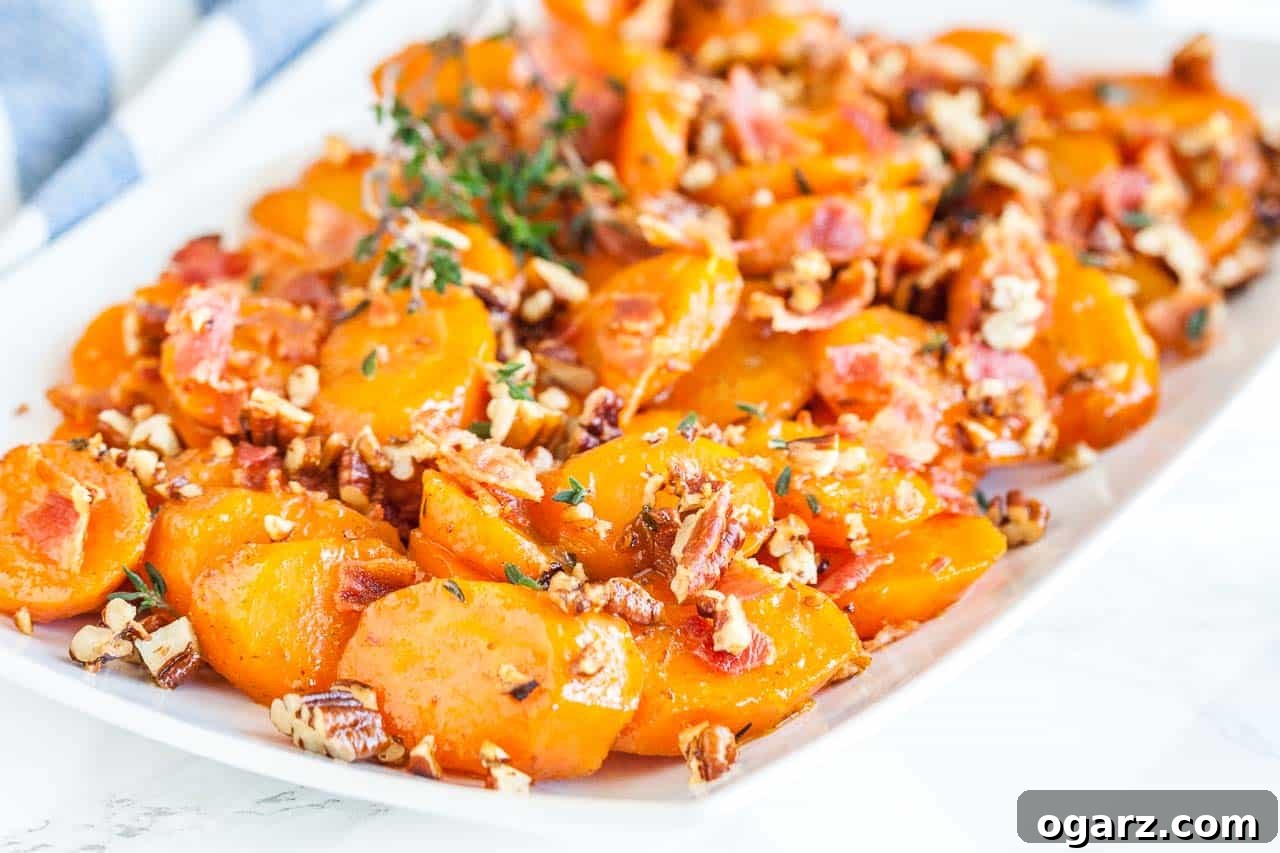 Brown Sugar Carrots: A Sweet Side Dish 5 A rectangular white plate of brown sugar-glazed carrots with bacon and pecans garnished with thyme.