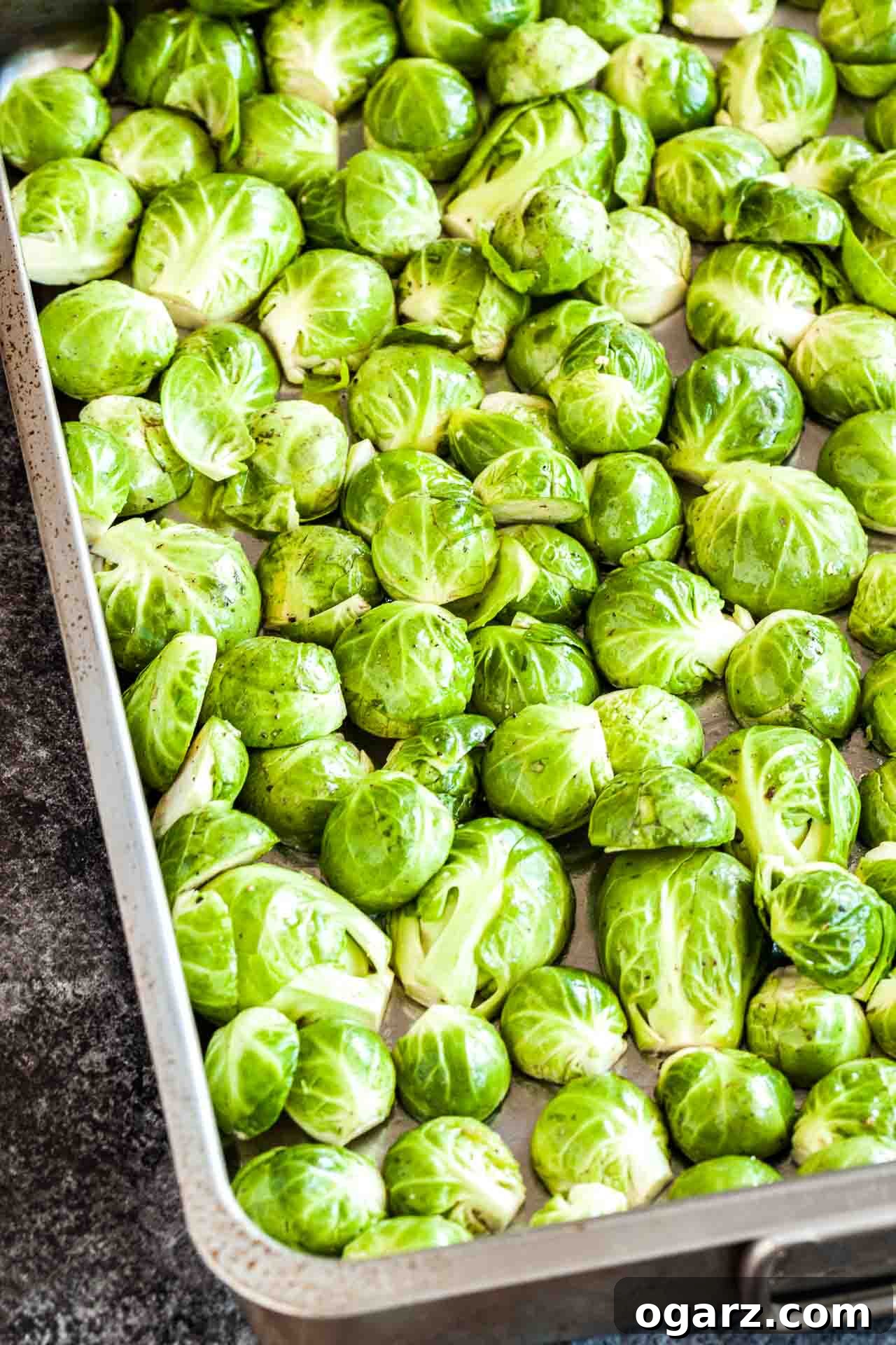 Crispy Brussels Sprouts with Smoked Pork Belly 4 Halved, raw brussels sprouts, covered in oil, salt and pepper on a baking sheet.
