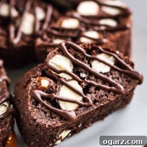 Several pieces of chocolate almond biscotti on a white plate.