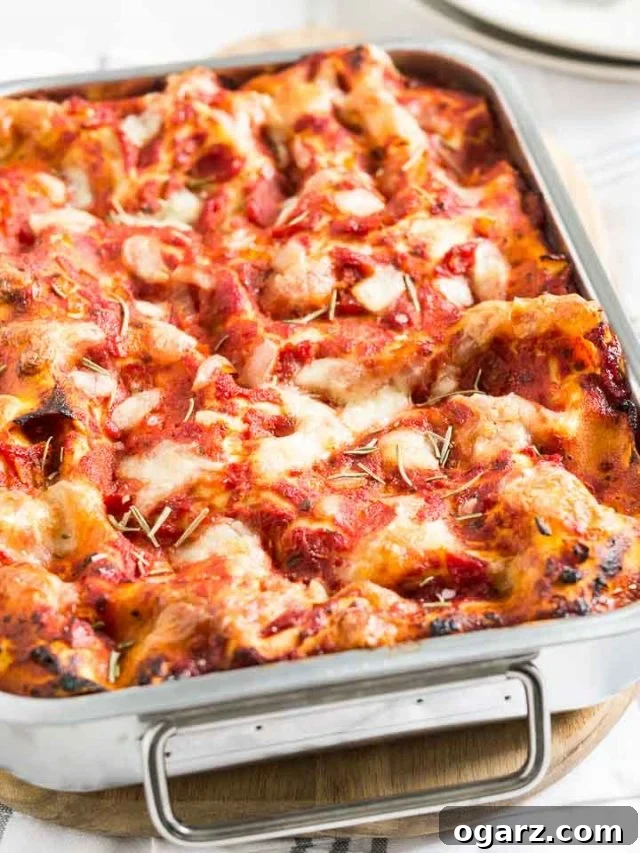 Golden Brown and Cheesy Spinach Lasagna Close-up of a perfectly baked spinach lasagna in a metal baking dish, ready to be served.