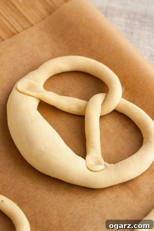 Hearty Bavarian Knots 5 Pretzel dough twisted and folded, showing the ends pressed into the thick part of the dough to form the classic pretzel shape.