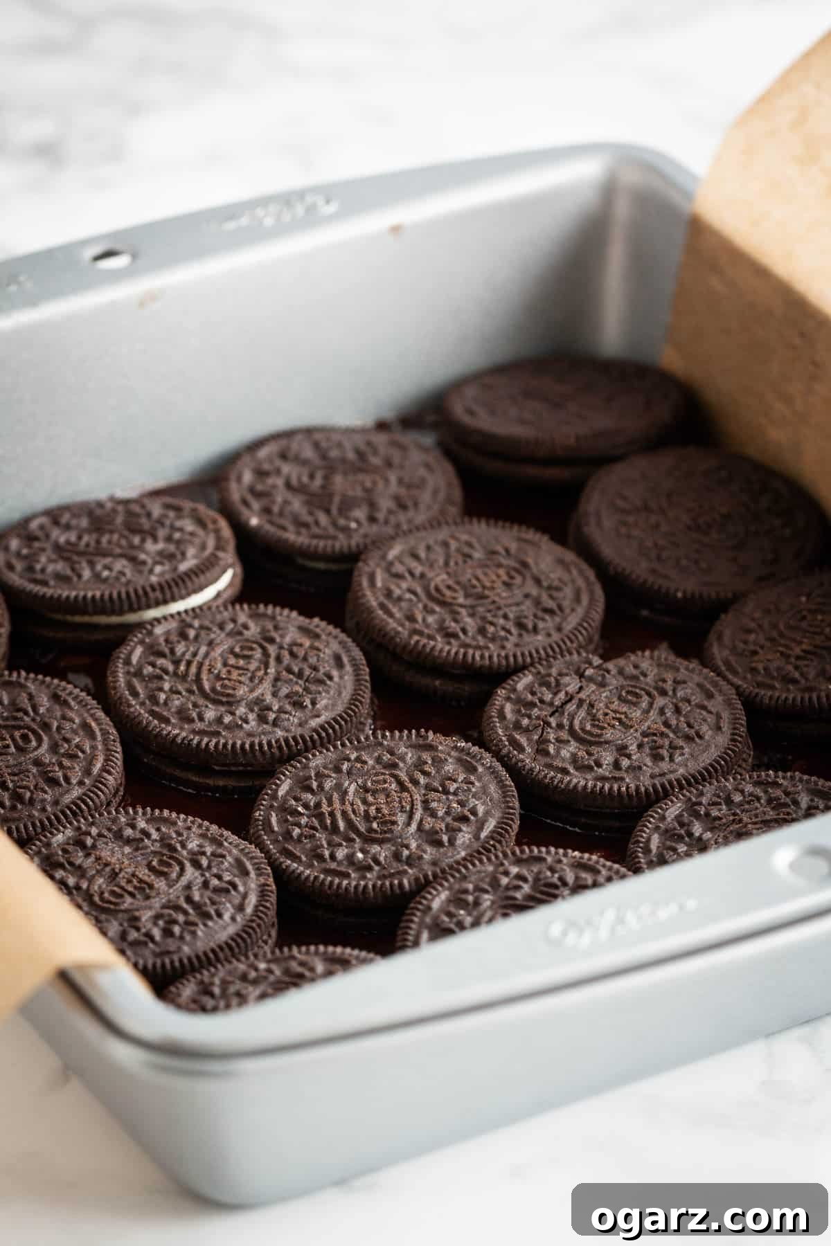 Decadent Oreo Fudge Brownies 3 A layer of cookies in a baking pan.