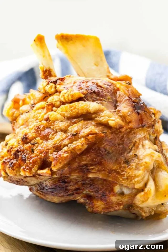 Crispy German Pork Hock (Schweinshaxe) A perfectly roasted German pork hock with golden, crispy skin resting on a wooden board, ready to be served.