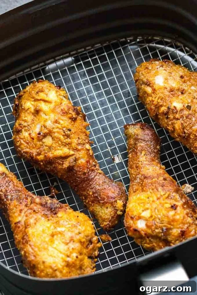 Golden Crispy Air Fryer Chicken 3 Battered chicken drumsticks arranged neatly in an air fryer basket, ready for cooking