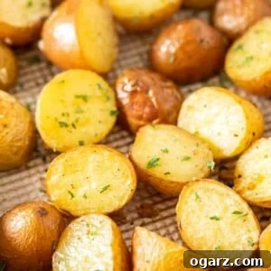 Close-up of a baking sheet with roasted potatoes, garnished with parsley.