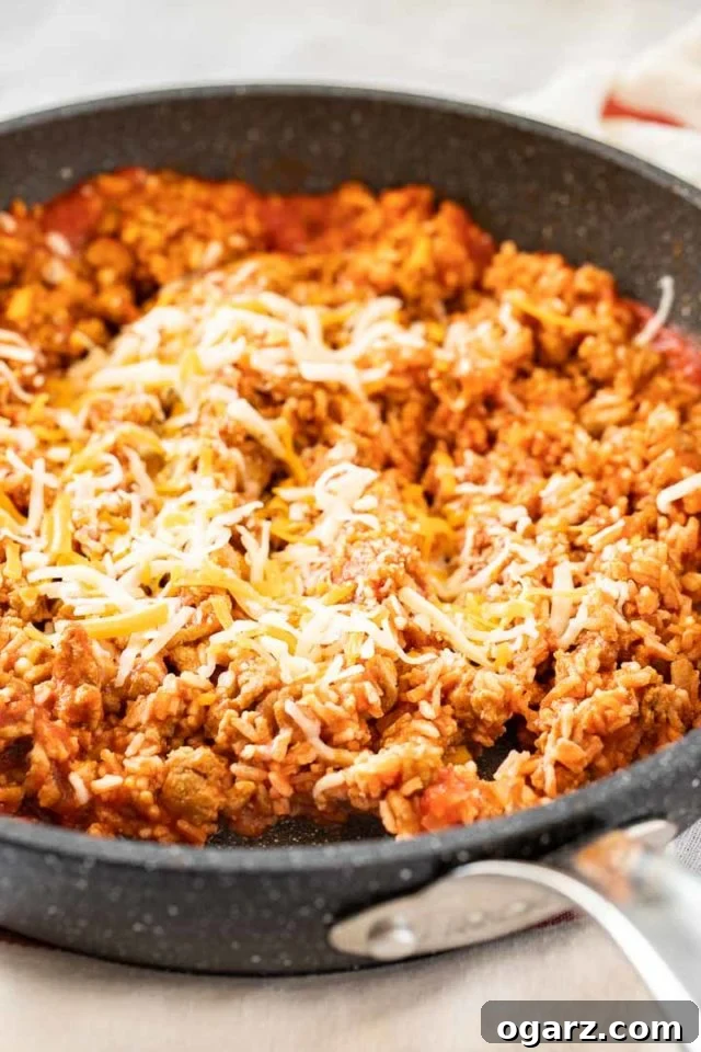 Classic Stuffed Green Peppers 4 A grey rock pan with ground turkey stuffing topped with shredded cheese.