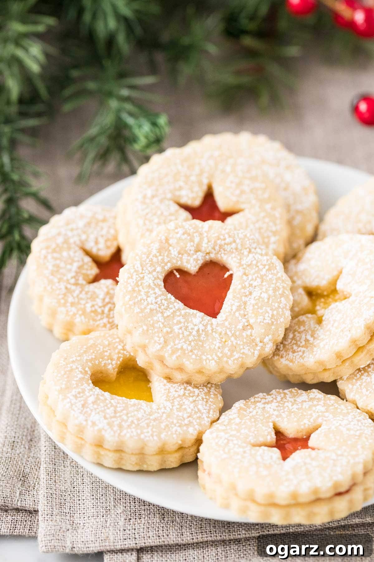 A charming stack of finished Linzer Cookies, showcasing their delicate artistry and inviting layers of shortbread and jam, ready to be enjoyed.