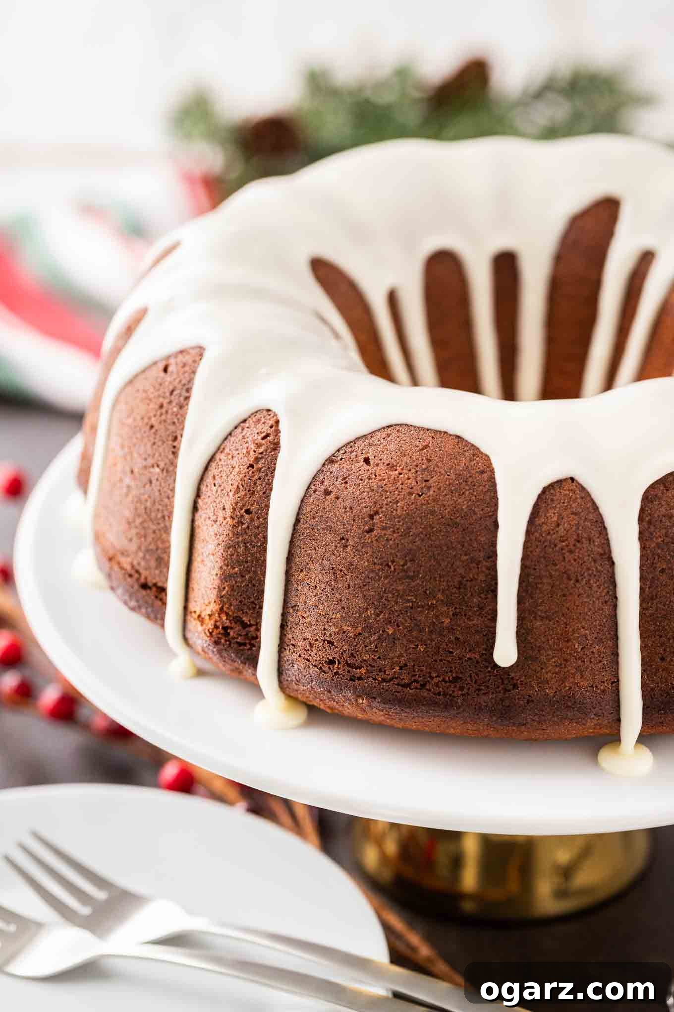 Perfectly Glazed Eggnog Bundt Cake for Festive Gatherings #BundtCakeRecipe #EggnogDessert #ChristmasBaking A beautifully baked Eggnog Bundt Cake, generously coated with a smooth white glaze that elegantly drips down its fluted sides, resting on a pristine white platter.
