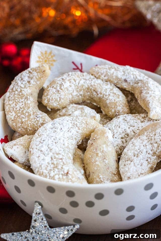 Melt-in-Your-Mouth German Vanilla Crescents 2 A white bowl with silver dots and a napkin, of Vanillekipferl cookies