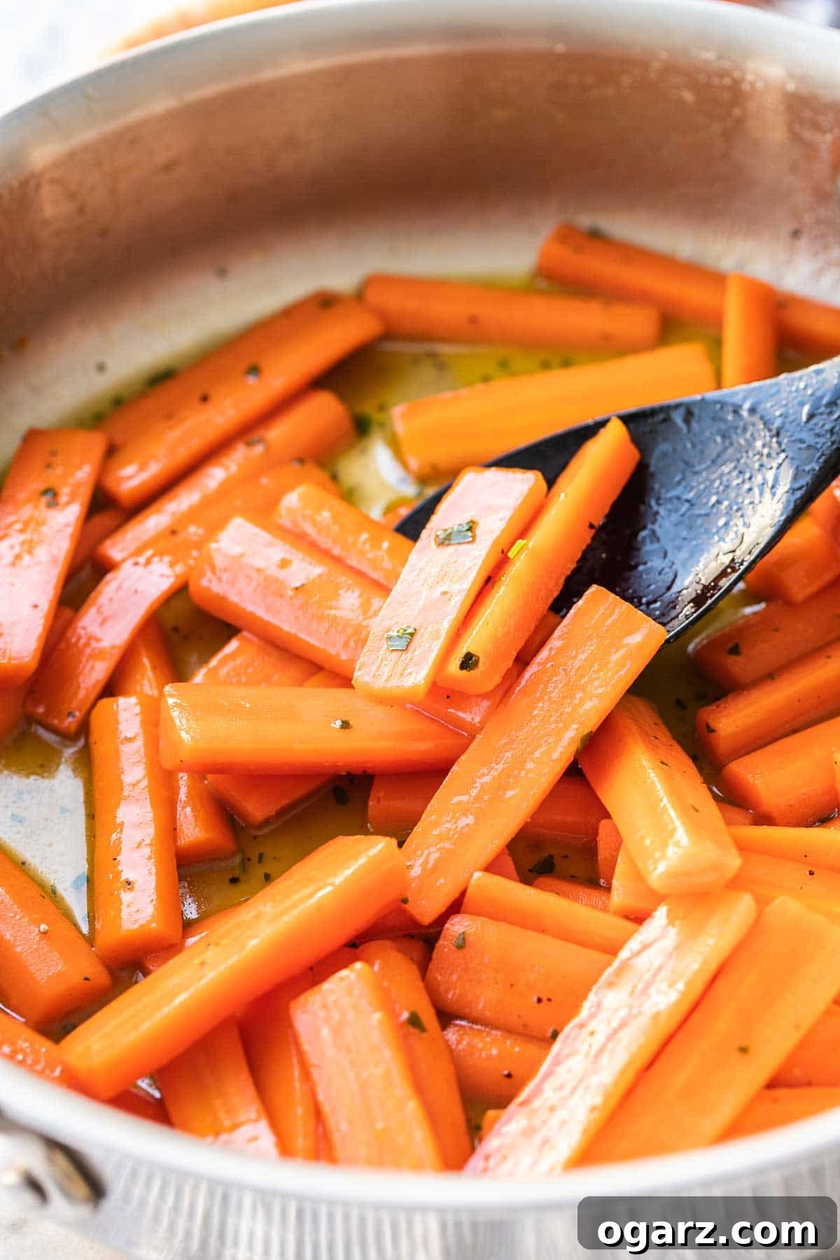 Delicious honey glazed carrots cooked on the stovetop, a healthy and sweet side dish perfect for holidays and everyday meals. #sidedish #glazedcarrots #healthy Carrots in a large skillet glazed with honey, ready to serve.