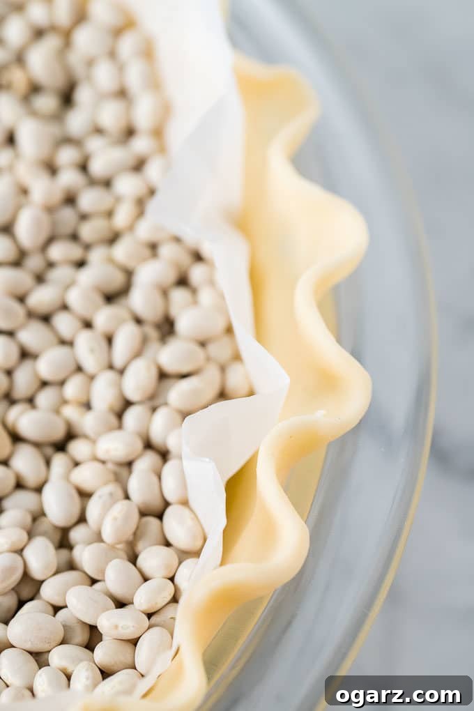 Heavenly Coconut Bliss 4 Close up of fluted Pie Crust (wave-shaped edge) in a glass baking dish with beans in the crust