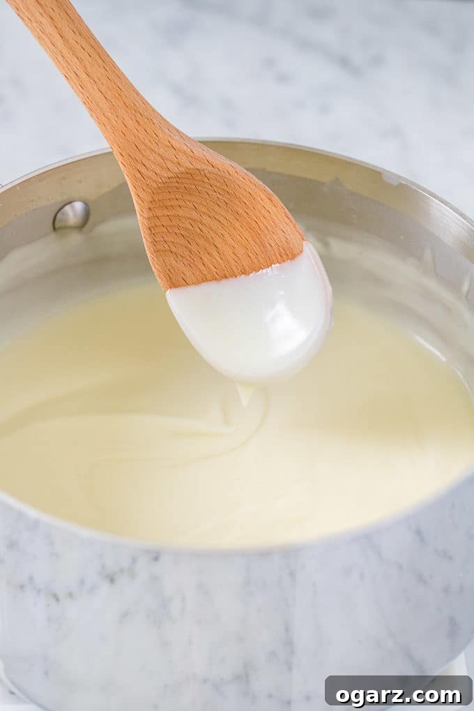 Heavenly Coconut Bliss 5 Coconut Cream Pie filling in a pot with a wooden cooking spoon