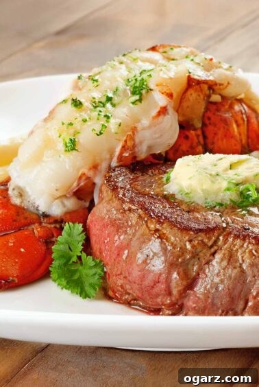Exquisite Surf and Turf featuring pan-seared filet mignon, succulent lobster tail, and a rich shallot compound butter, artfully arranged on a plate.