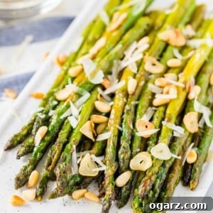 Golden Roasted Asparagus 6 Roasted asparagus on a serving platter, topped with roasted garlic, Parmigiano and pine nuts
