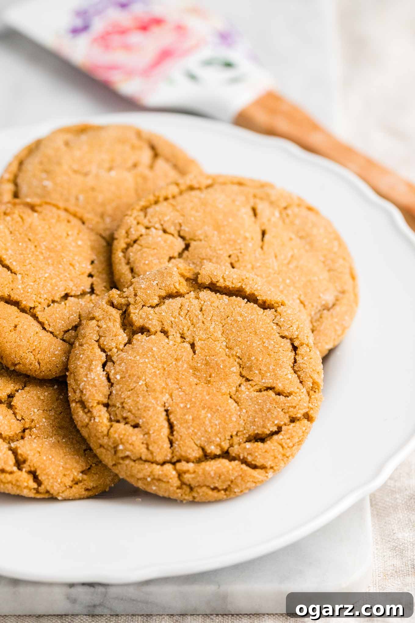 Irresistible Spiced Ginger Snaps 4 Cookies on a plate with a spatula in the background, ready to be served.