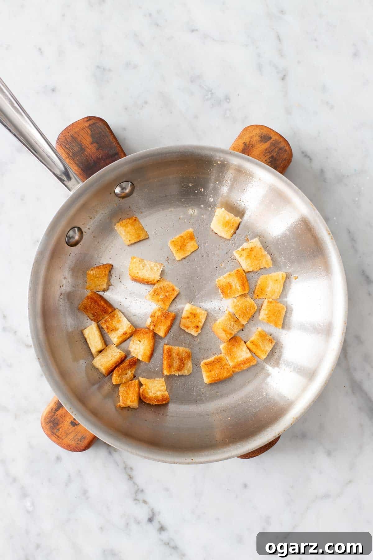 Pillowy Potato Bites 10 Small cubes of white bread browning in a pan with melted butter, prepared for the traditional dumpling filling.