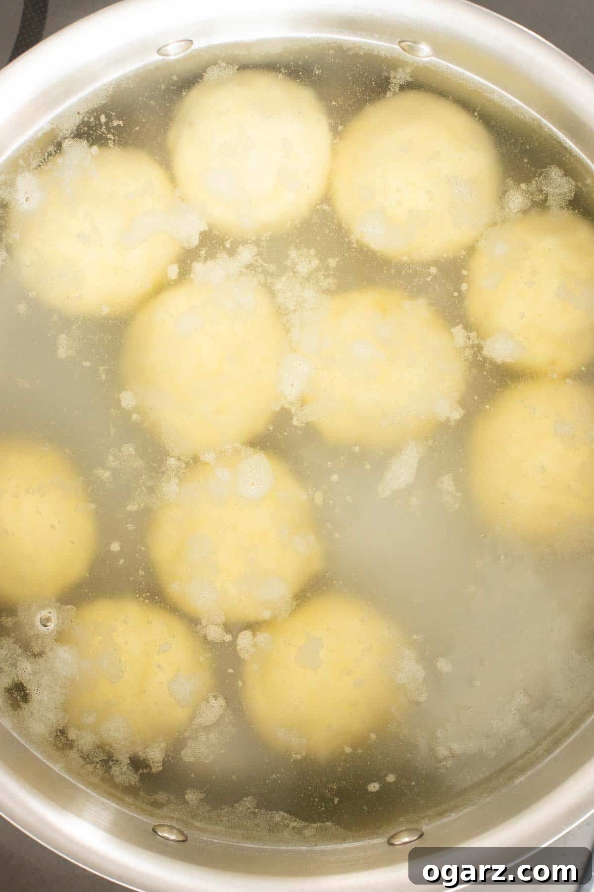 Pillowy Potato Bites 14 German potato dumplings gently cooking in hot (not boiling) water in a large pot, maintaining their perfect form.