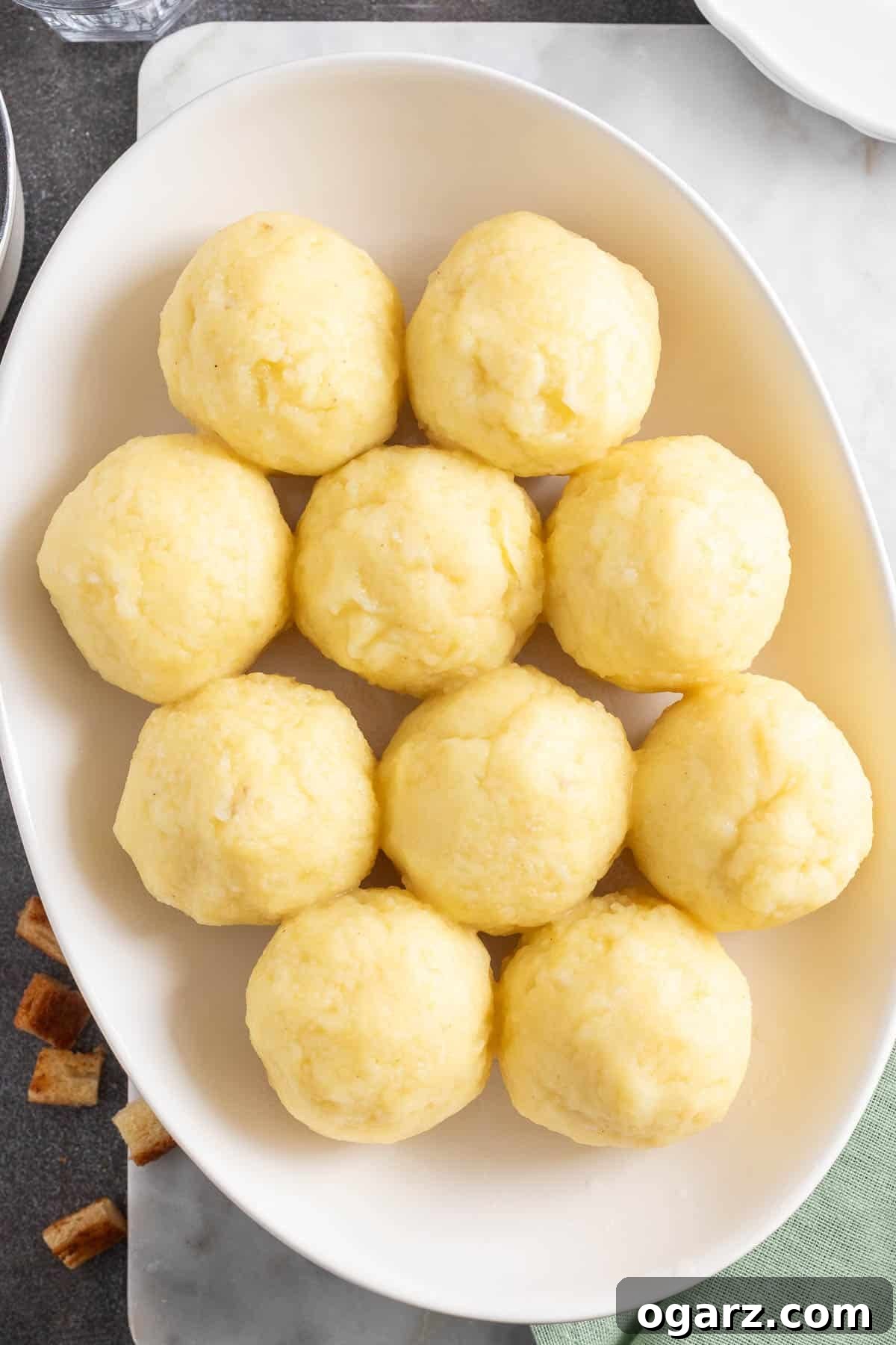 Pillowy Potato Bites 4 A grand serving plate piled high with golden-brown German potato dumplings, glistening and ready for gravy.